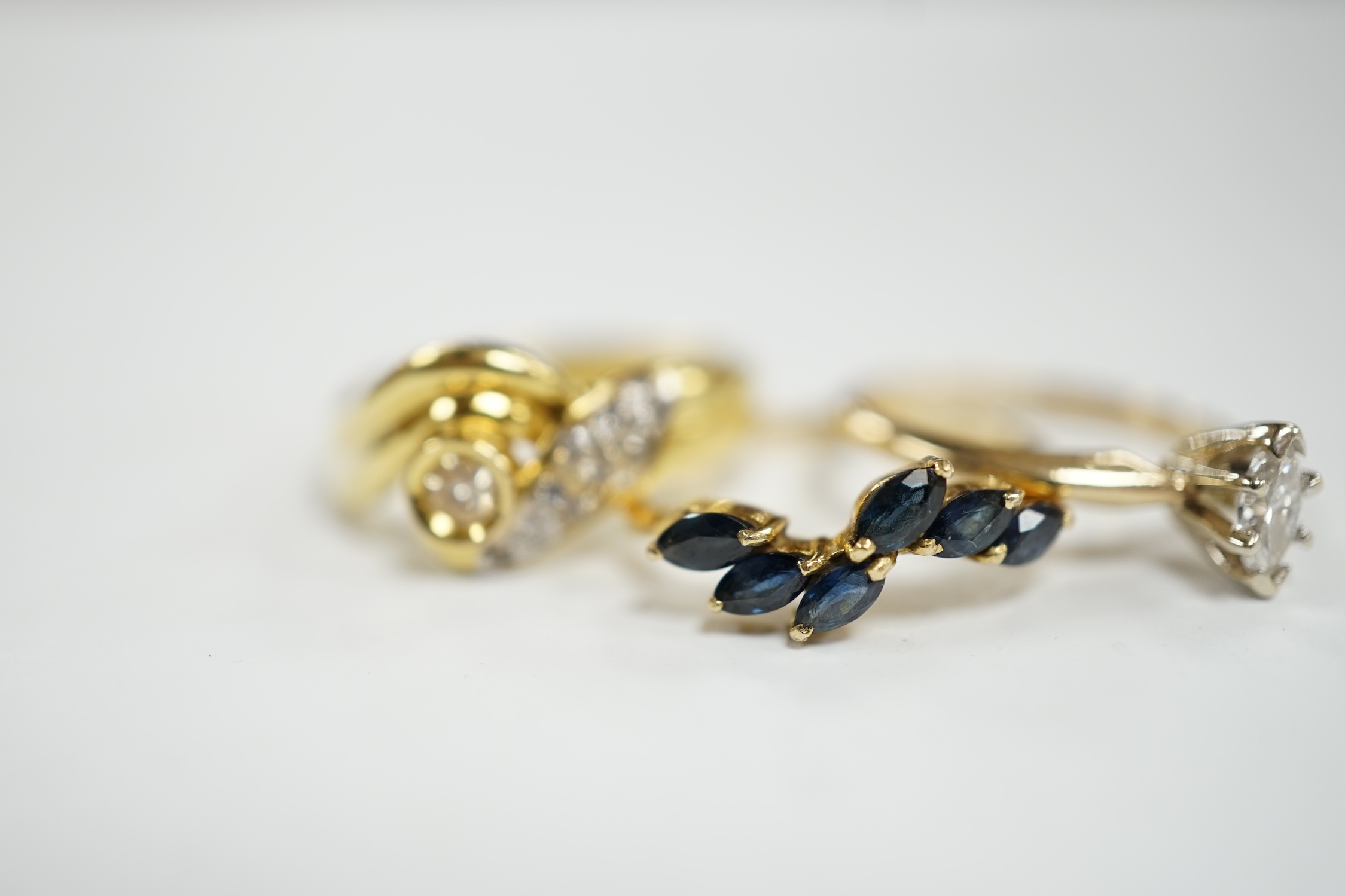 Three assorted modern 14k and gem set rings, including single stone marquise cut diamond, diamond chip set and sapphire set, gross weight 7.7 grams.